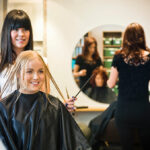 Salon worker cutting womens wet hair